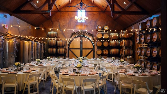 wine cellar featuring high vaulted ceiling, beam ceiling, wood ceiling, and an inviting chandelier