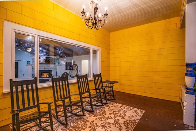 dining room featuring an inviting chandelier, a glass covered fireplace, and wood finished floors