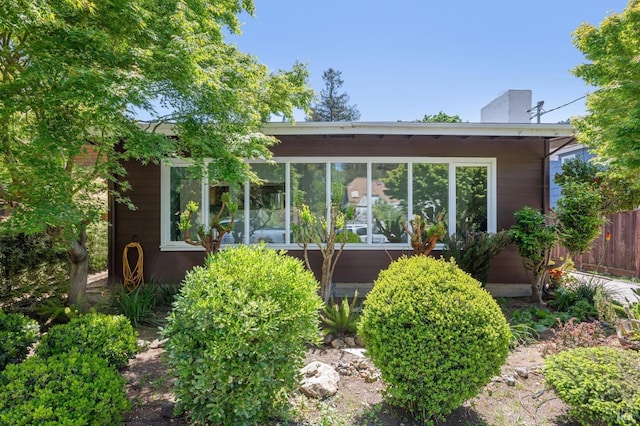 back of house featuring a sunroom and fence