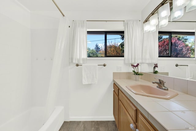 bathroom with shower / bath combination with curtain, vanity, wood finished floors, and plenty of natural light