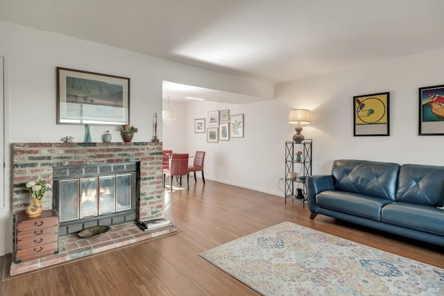 living room featuring baseboards, wood finished floors, and a fireplace