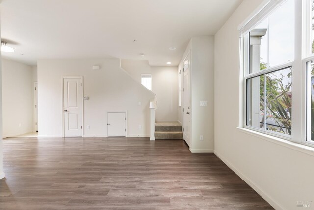 unfurnished living room with stairway, baseboards, wood finished floors, and recessed lighting