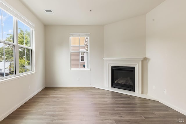 unfurnished living room with a wealth of natural light and wood finished floors