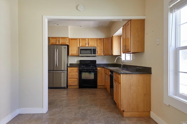 kitchen with plenty of natural light, baseboards, a sink, and black appliances