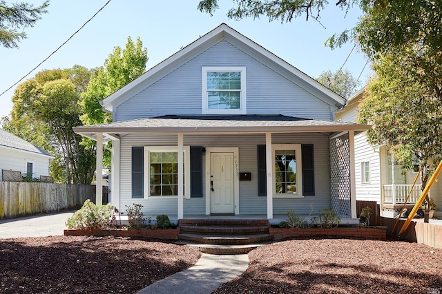 bungalow-style house with a porch and fence