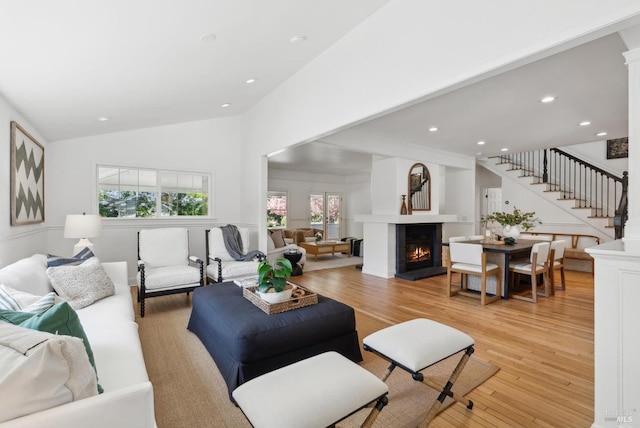 1030 Thompson Ln, Petaluma, CA 94952 - living area with stairs, light wood finished floors, lofted ceiling, a warm lit fireplace, and recessed lighting