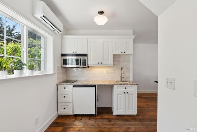 1030 Thompson Ln, Petaluma, CA 94952 - kitchen with stainless steel microwave, an AC wall unit, a sink, tasteful backsplash, and dark wood finished floors