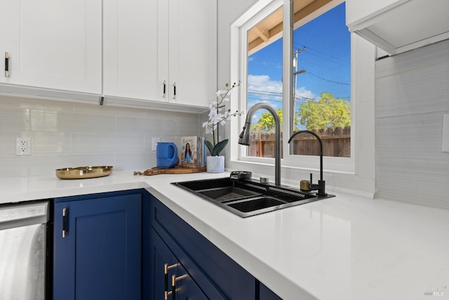 kitchen featuring a sink, light countertops, blue cabinetry, backsplash, and dishwashing machine