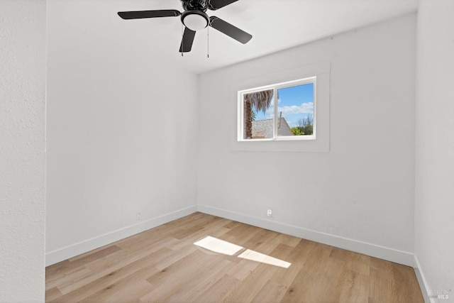 empty room featuring wood finished floors, baseboards, and ceiling fan