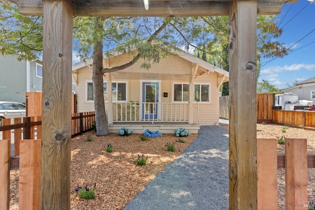 bungalow featuring fence and covered porch