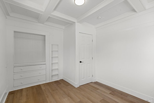 unfurnished bedroom with coffered ceiling, beam ceiling, wood finished floors, and baseboards