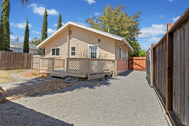 rear view of house with a patio, a fenced backyard, and a deck