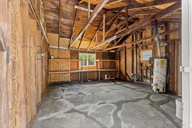 misc room with a garage, vaulted ceiling, and water heater