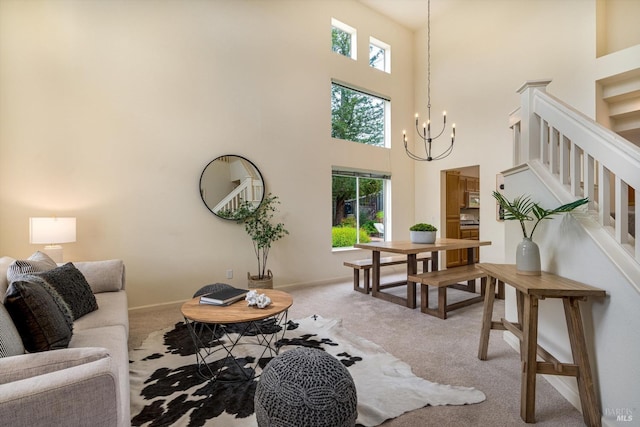 living area featuring light carpet, a chandelier, a high ceiling, and stairs