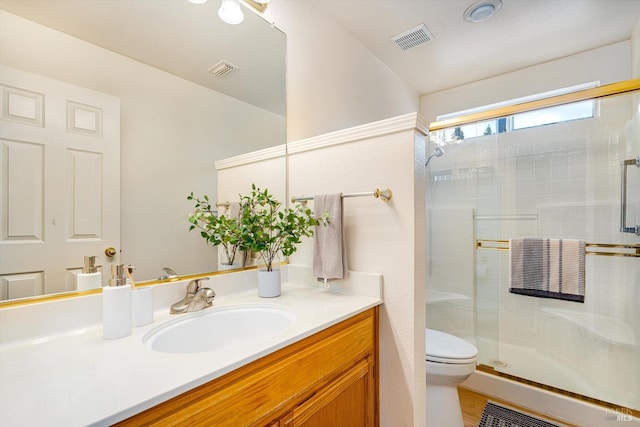 full bath with visible vents, toilet, a stall shower, and vanity