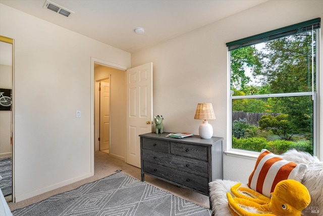 sitting room with plenty of natural light, baseboards, visible vents, and carpet floors