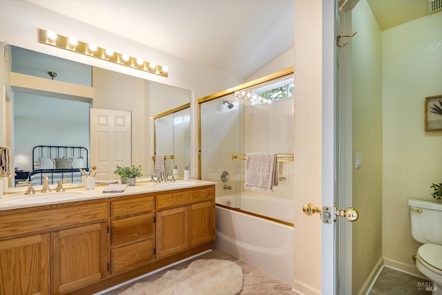 bathroom featuring a sink, double vanity, toilet, vaulted ceiling, and combined bath / shower with glass door