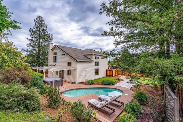 pool featuring a fenced backyard, a hot tub, and a patio
