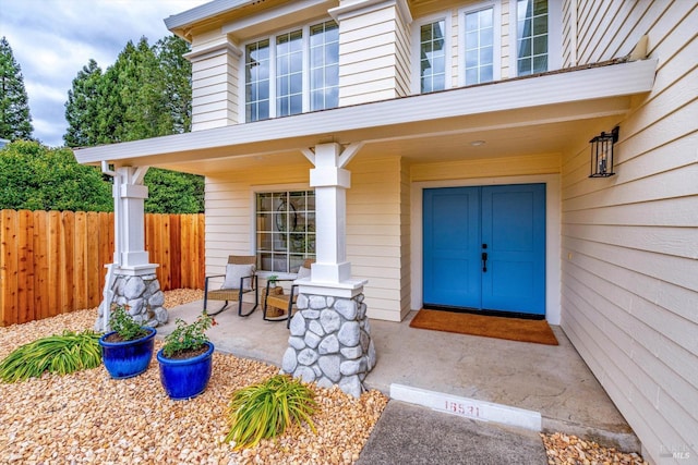 property entrance featuring fence and a porch