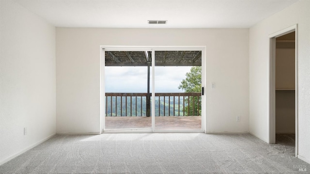 spare room featuring carpet floors and visible vents