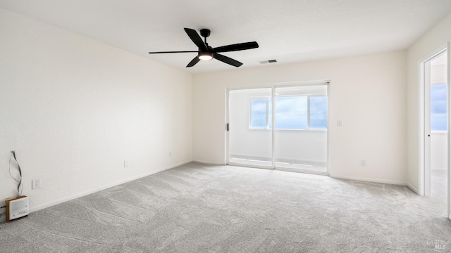 empty room featuring baseboards, visible vents, carpet floors, and ceiling fan