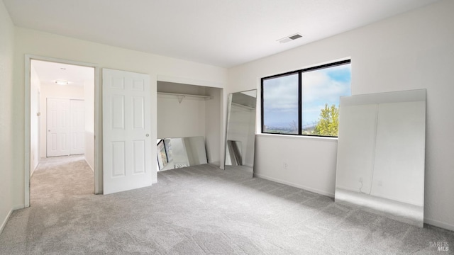 unfurnished bedroom featuring baseboards, carpet floors, visible vents, and a closet