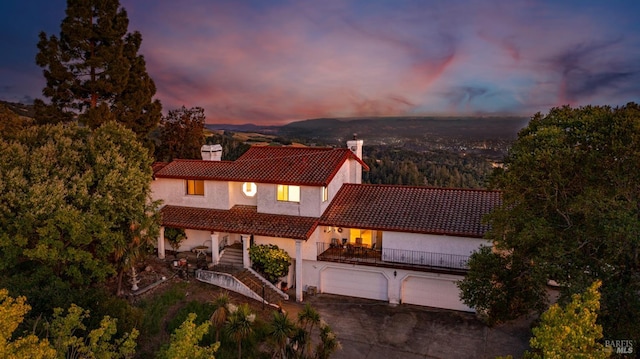 5750 Lichau Rd, Penngrove, CA 94951 - mediterranean / spanish-style home with a tiled roof, a chimney, stairway, an attached garage, and stucco siding