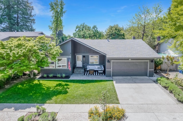 mid-century modern home with a front lawn, concrete driveway, fence, an attached garage, and a shingled roof