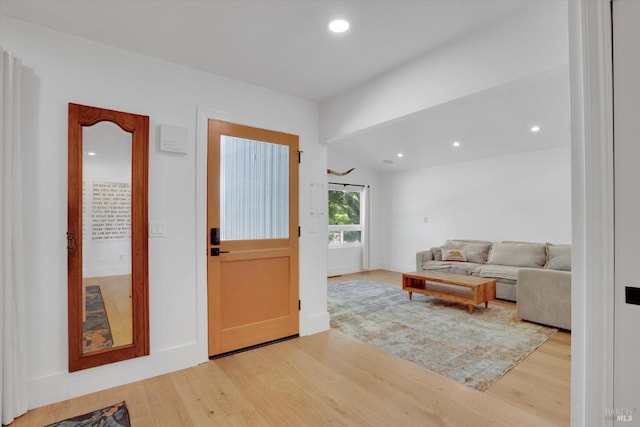 foyer featuring baseboards, wood finished floors, and recessed lighting