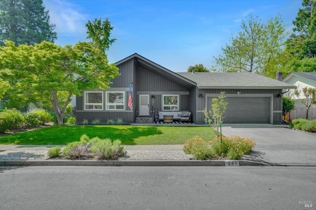 mid-century inspired home featuring a front lawn, concrete driveway, entry steps, an attached garage, and board and batten siding