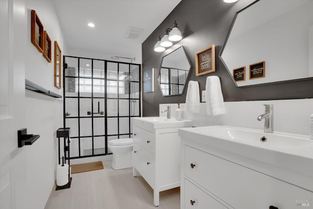 bathroom with two vanities, visible vents, a sink, and a walk in shower