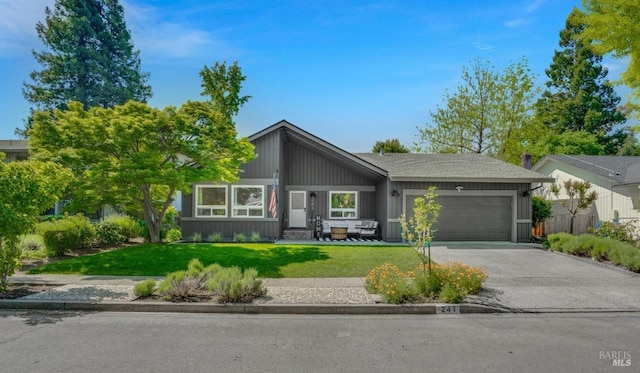mid-century inspired home with entry steps, an attached garage, a front lawn, and aphalt driveway