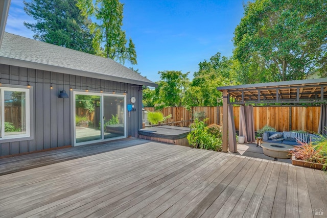 wooden terrace featuring a fire pit and a fenced backyard