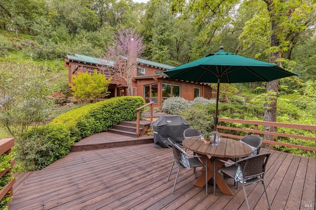 deck featuring grilling area and outdoor dining space