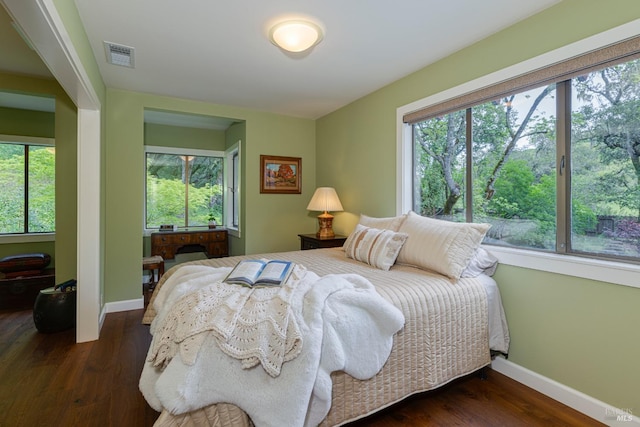 bedroom featuring visible vents, baseboards, and multiple windows