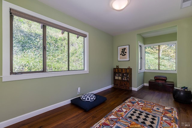 interior space featuring baseboards, a healthy amount of sunlight, hardwood / wood-style floors, and visible vents