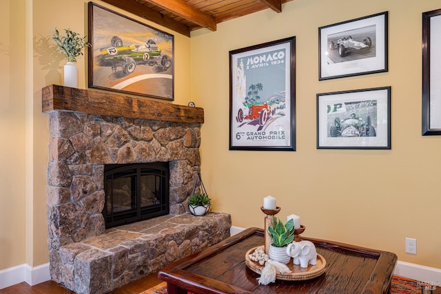 interior space with a stone fireplace, wood finished floors, and baseboards