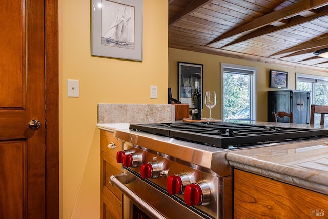 kitchen with high end stove, beam ceiling, wooden ceiling, and brown cabinetry