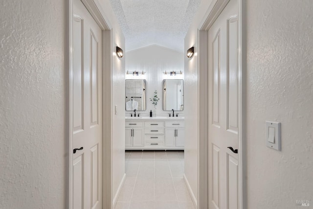 1006 Armsby Way, Suisun City, CA 94585 - hall featuring a sink, lofted ceiling, light tile patterned floors, a textured ceiling, and a textured wall