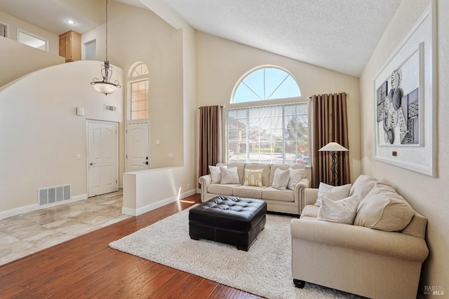 1006 Armsby Way, Suisun City, CA 94585 - living area featuring hardwood / wood-style floors, high vaulted ceiling, a textured ceiling, and baseboards