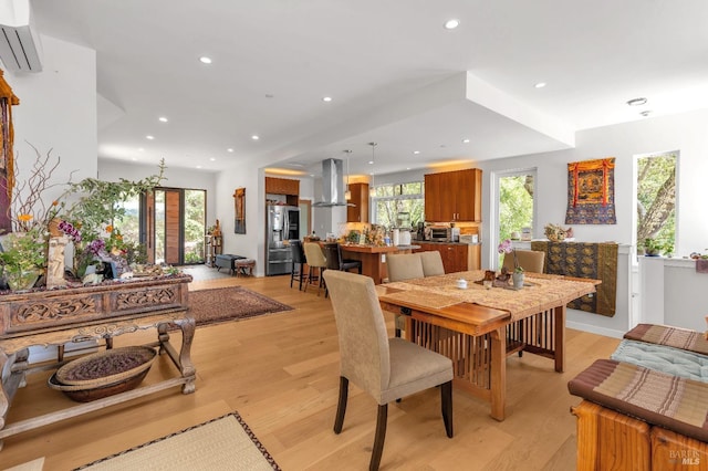dining room featuring recessed lighting, a wall unit AC, and light wood-style flooring