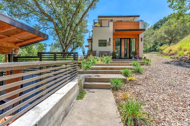 rear view of property with fence and stucco siding