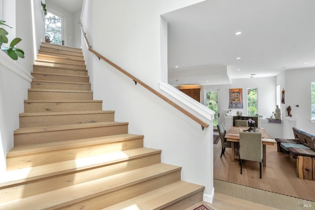 stairway with recessed lighting and wood finished floors