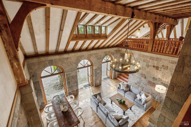 unfurnished living room with lofted ceiling, wood finished floors, and a chandelier