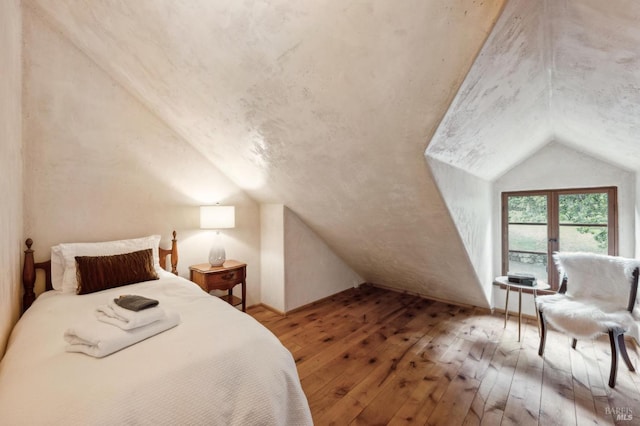 bedroom featuring vaulted ceiling and wood-type flooring
