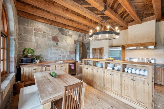 kitchen featuring light wood-style flooring, beam ceiling, arched walkways, wood counters, and appliances with stainless steel finishes