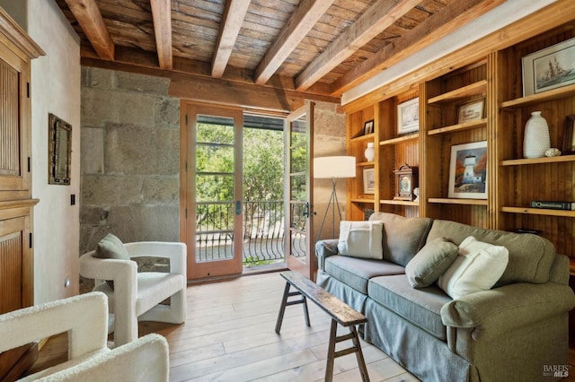 sitting room with beamed ceiling, wooden ceiling, built in features, and light wood-style flooring