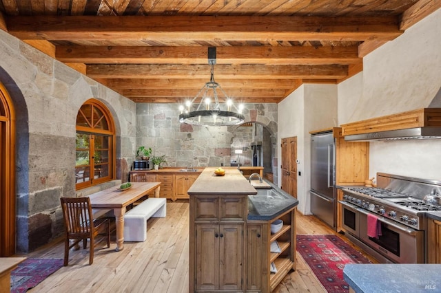 kitchen with wood ceiling, light wood-style flooring, arched walkways, and high quality appliances
