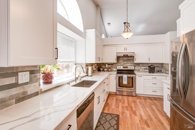 kitchen with stainless steel appliances, under cabinet range hood, a sink, and light stone counters