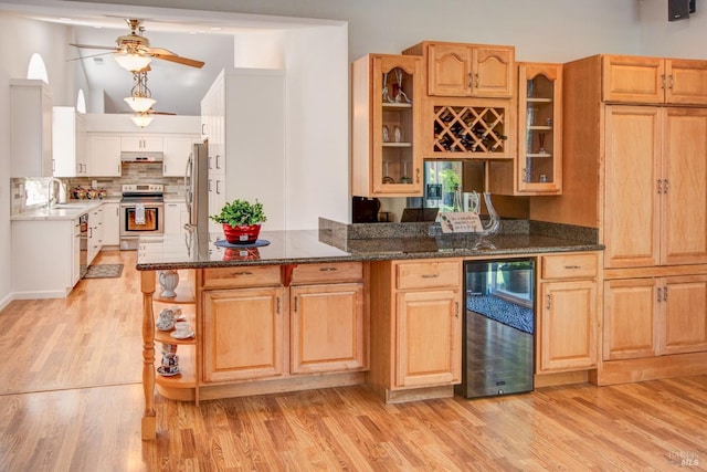 kitchen featuring a sink, ceiling fan, under cabinet range hood, beverage cooler, and appliances with stainless steel finishes